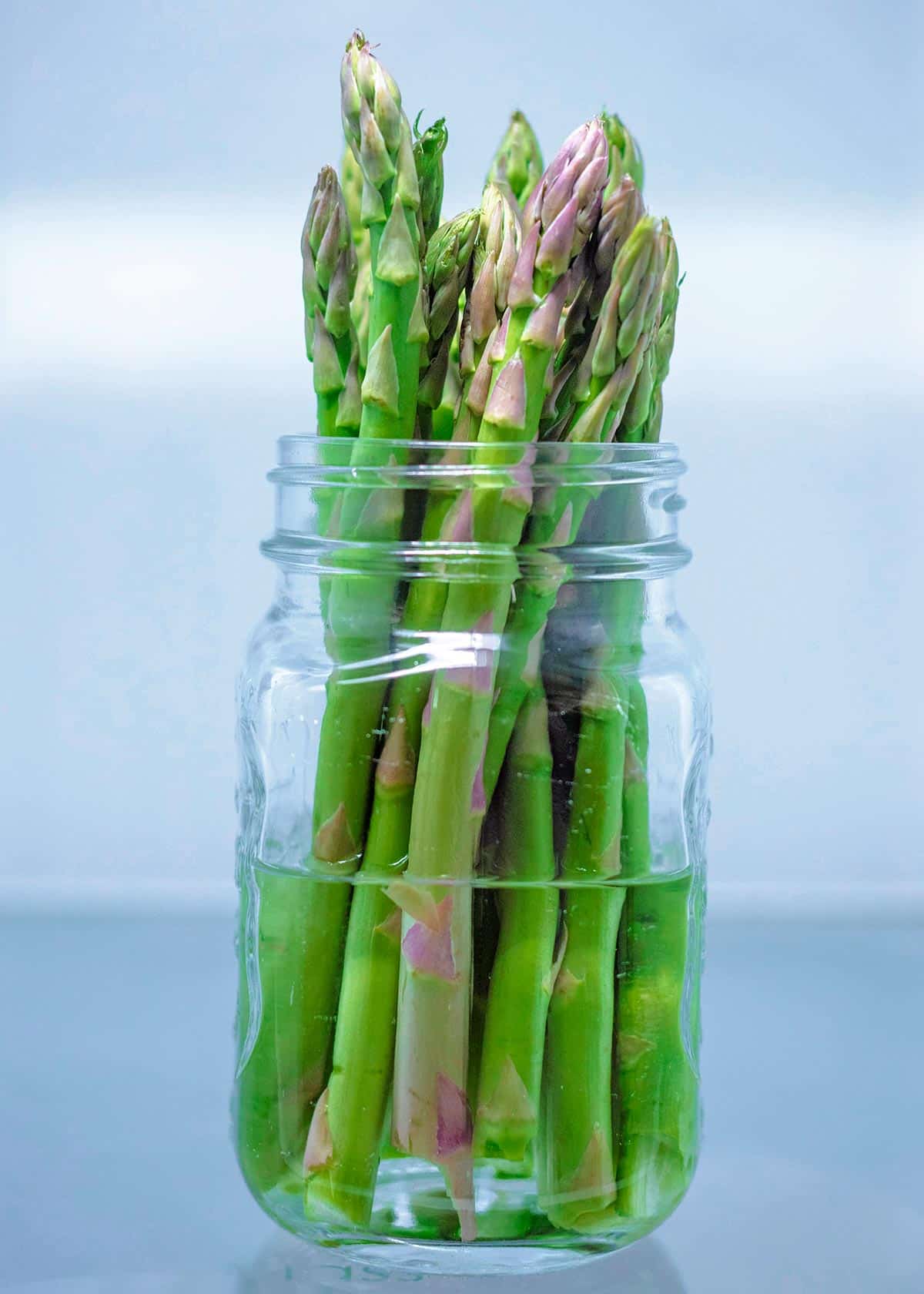Asparagus spears stood in a jar of water.