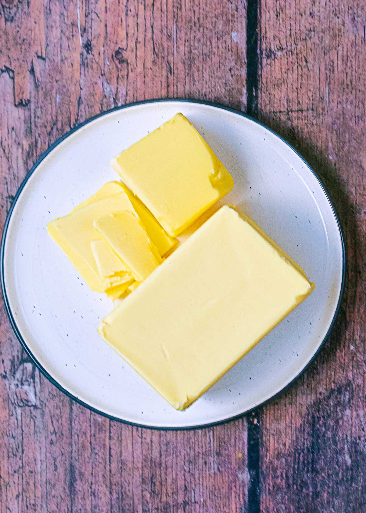 A plate of butter on a wooden surface.