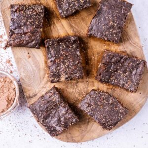 Squares of chocolate banana brownies on a wooden board.
