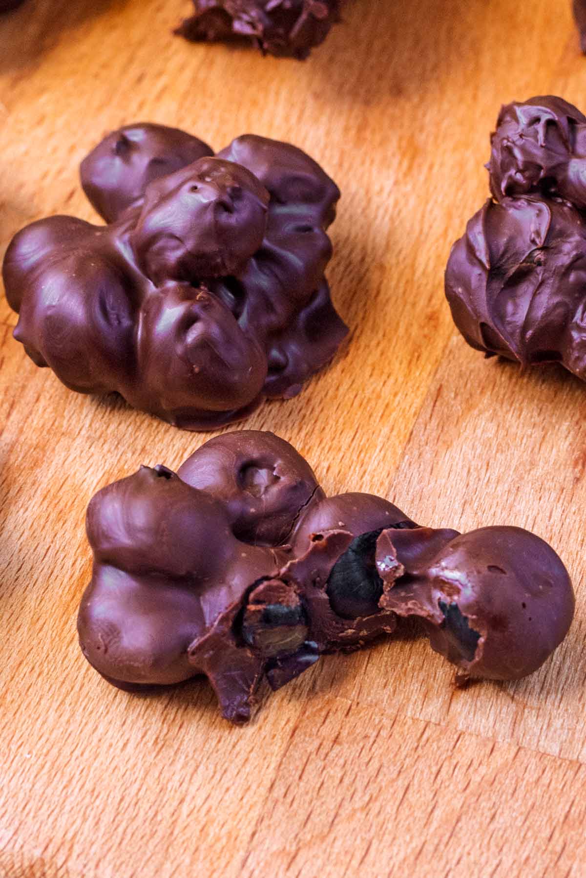 Chocolate coated blueberries pulled apart showing the blueberries inside.