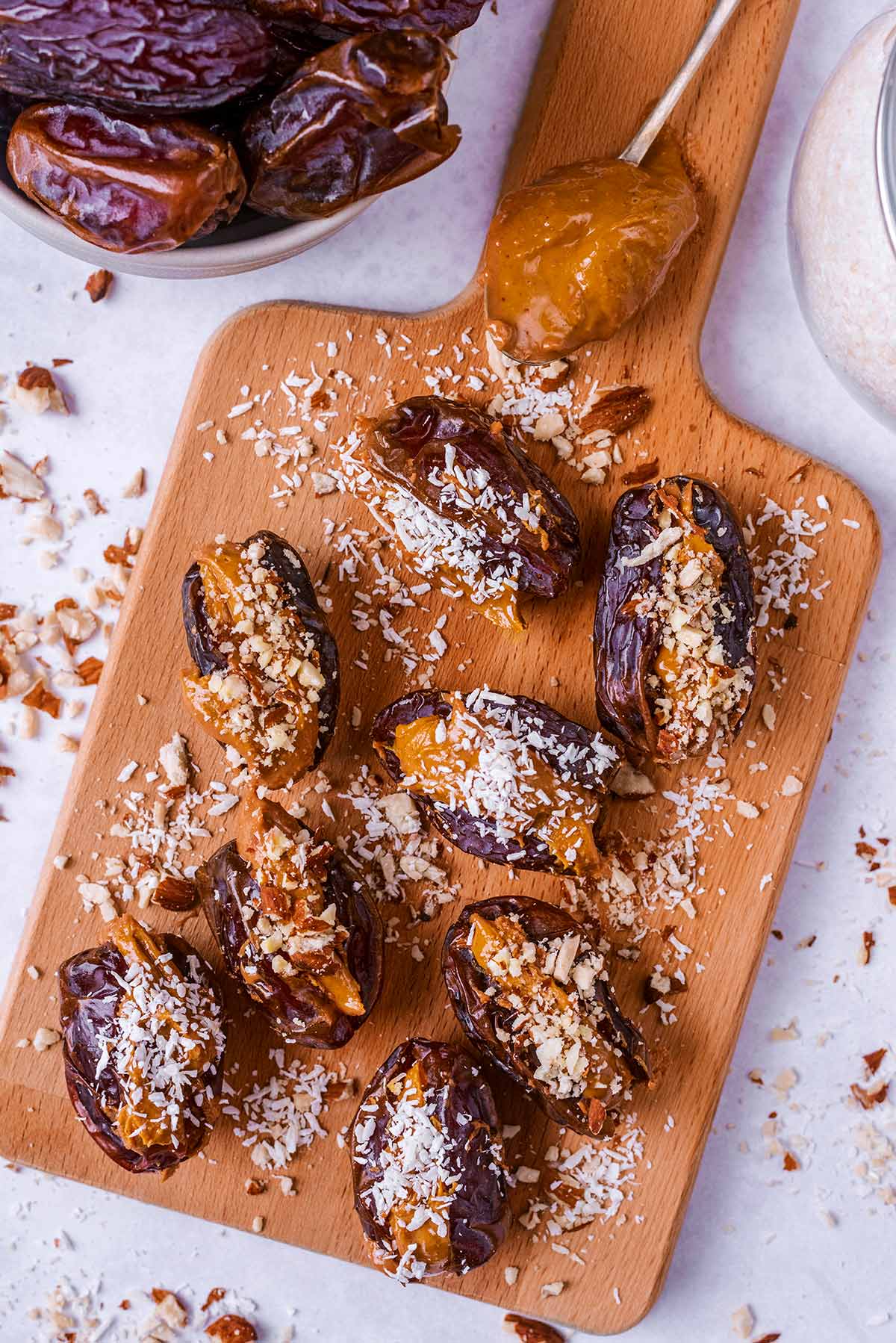Eight dates stuffed with nut butter and topped with coconut and nuts.