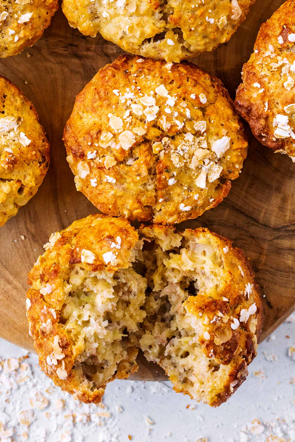 Two banana muffins, one of them is broken in half, showing the inside.