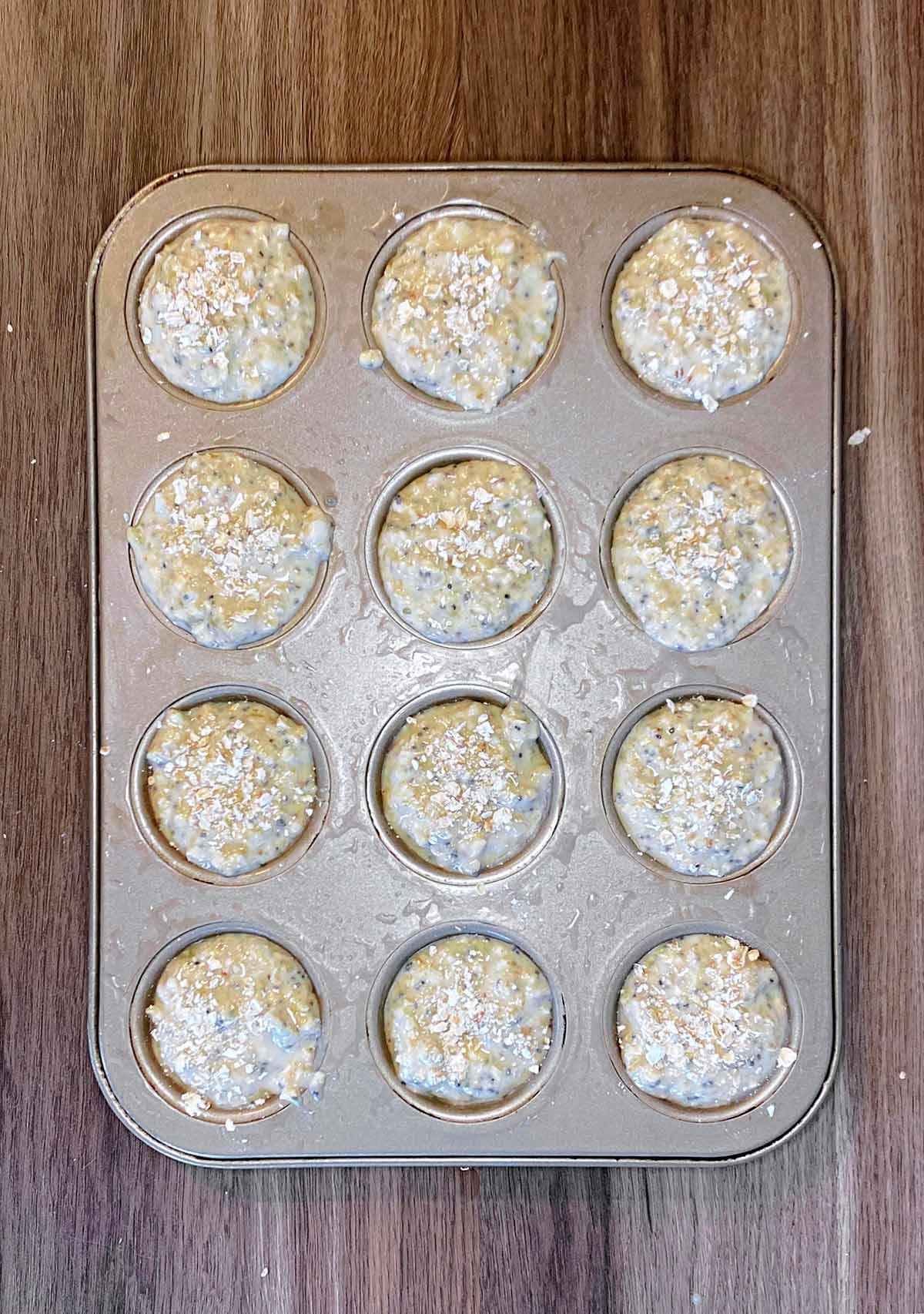 Twelve hole muffin tin filled with muffin batter.