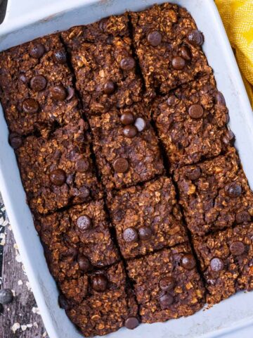 A baking dish containing brownie baked oatmeal that has been cut into twelve squares.