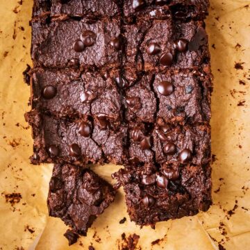 A slab of applesauce brownies on a sheet of parchment paper.