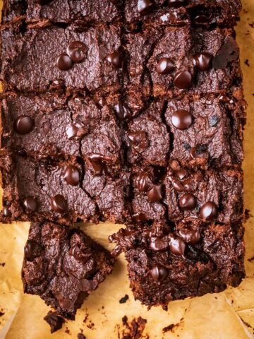 A slab of applesauce brownies on a sheet of parchment paper.