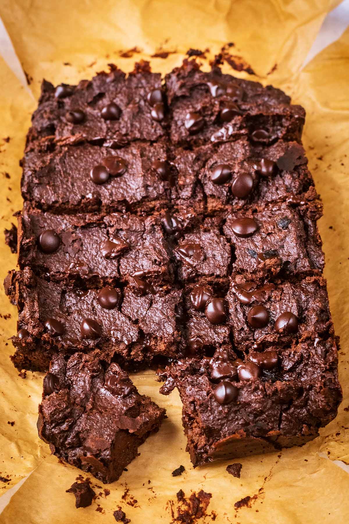 Ten chocolate brownies on a sheet of parchment paper.