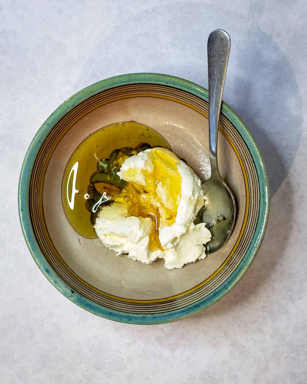 A bowl with cream cheese and honey in it.