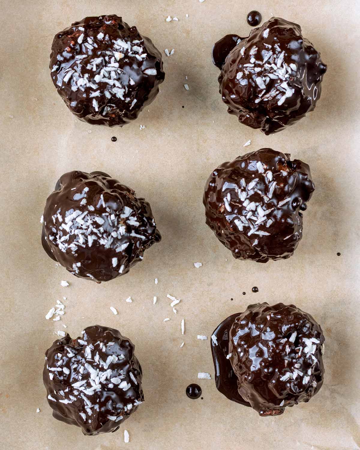 The crispy date balls coated in melted chocolate and topped with desiccated coconut.