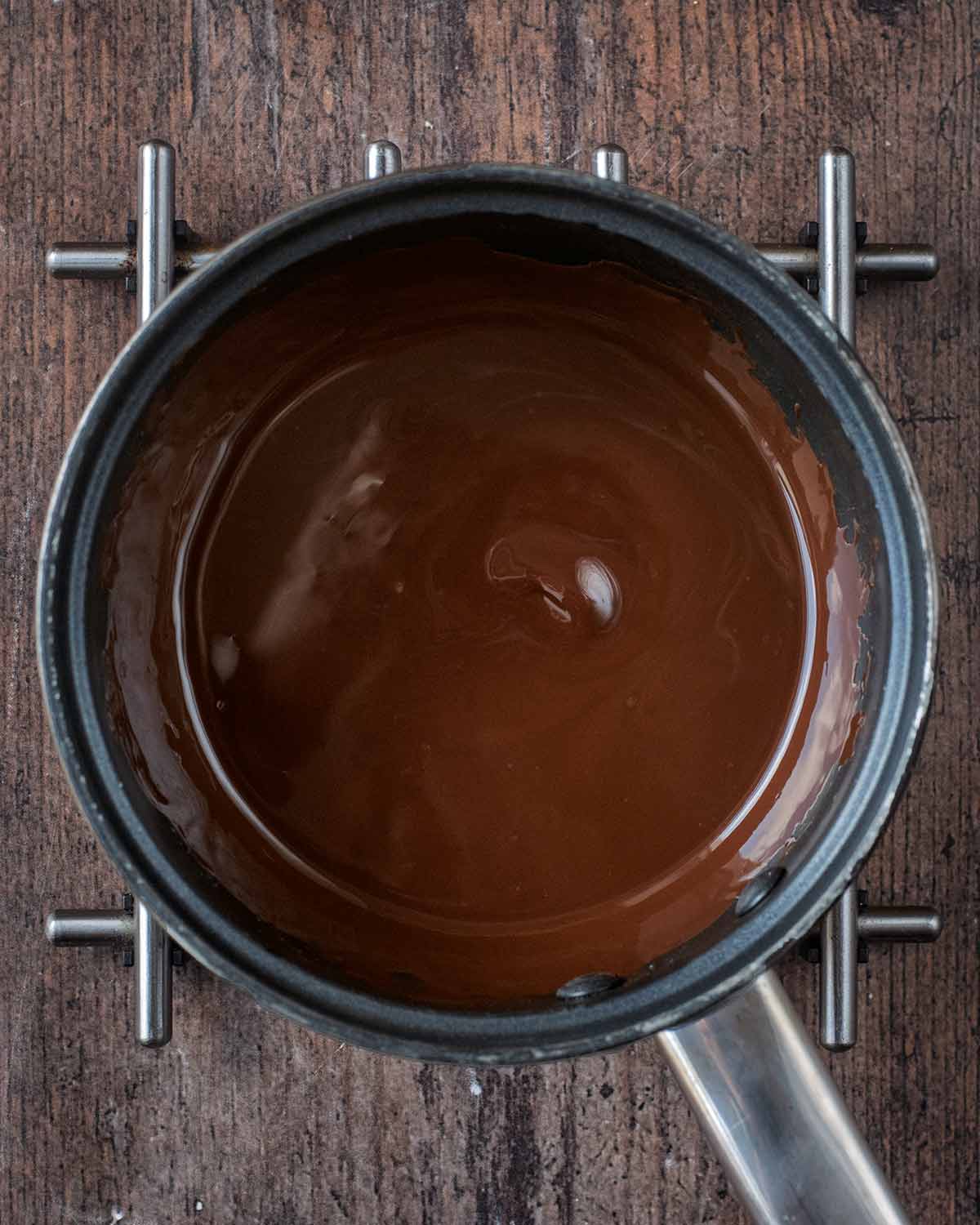 A small saucepan containing melted chocolate.