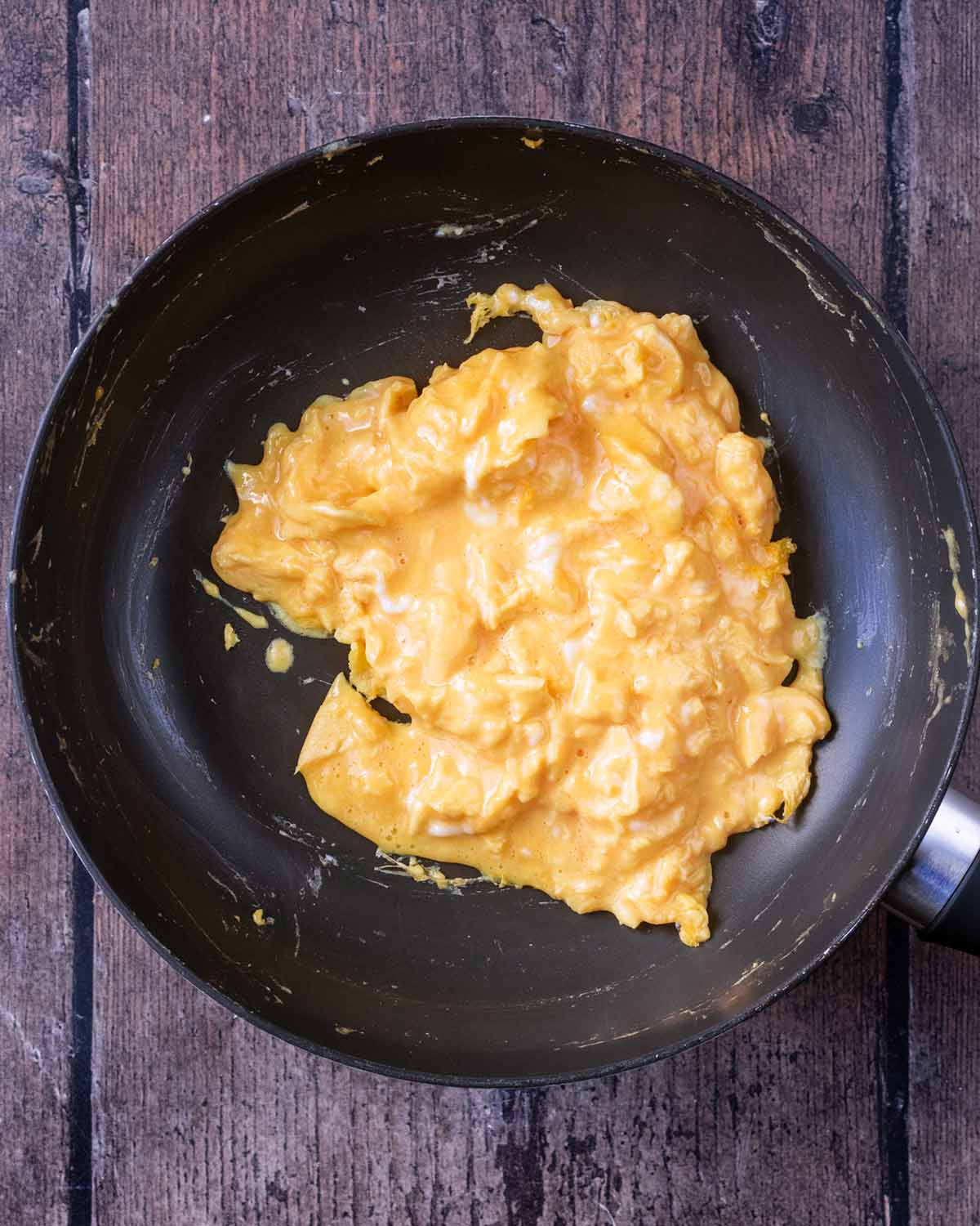 Scrambled eggs cooking in a pan.