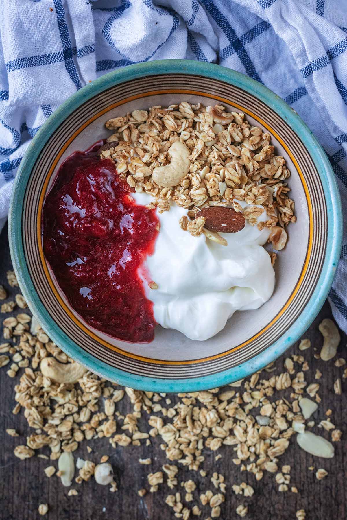 A bowl of yogurt, granola and strawberry compote.