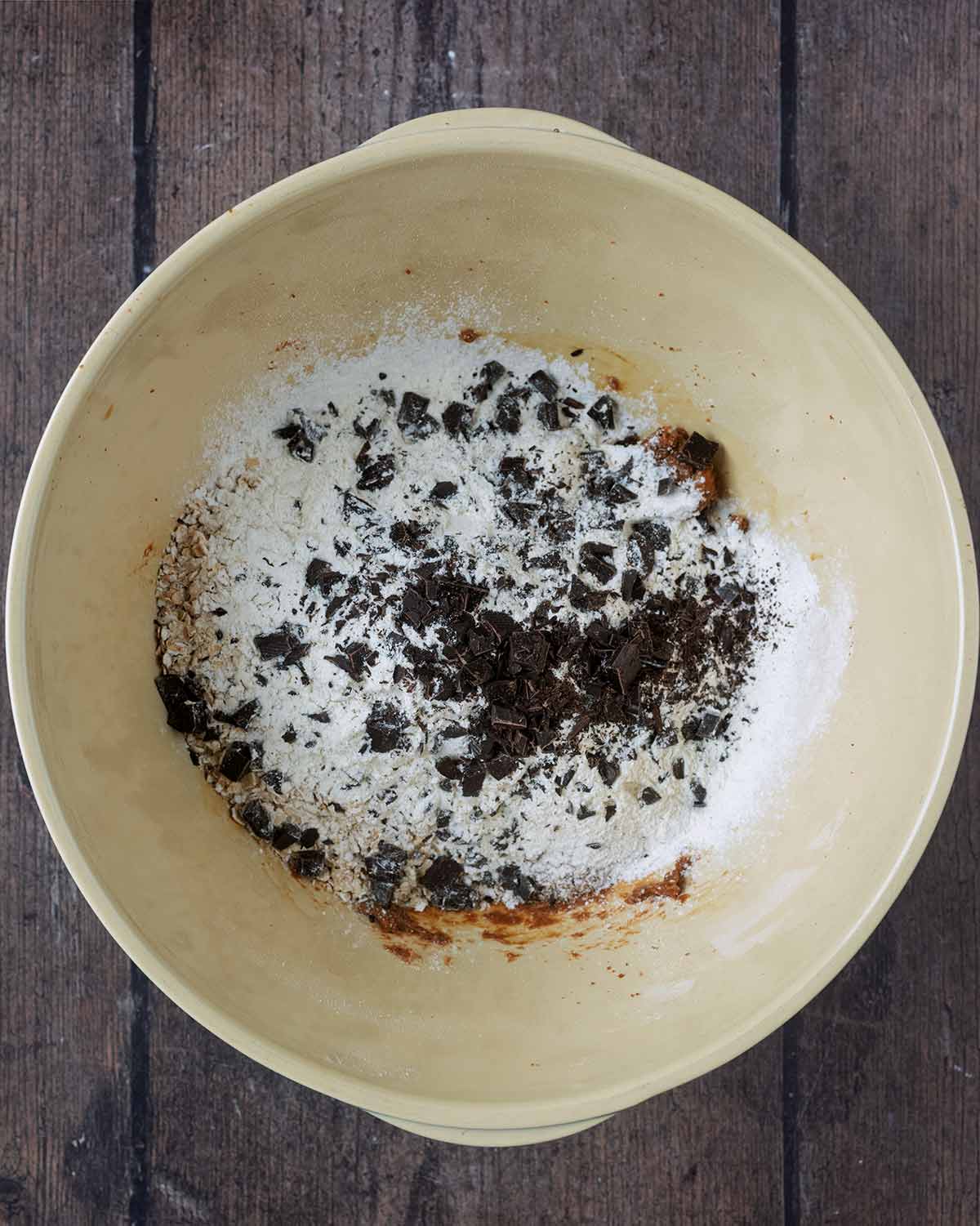 Flour, oats and chocolate chips added to the bowl.